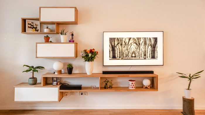 a living room with a tv and a plant on the wall at The  Jaxon