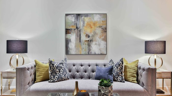 a modern living room with a gray couch and two pillows at The  Jaxon