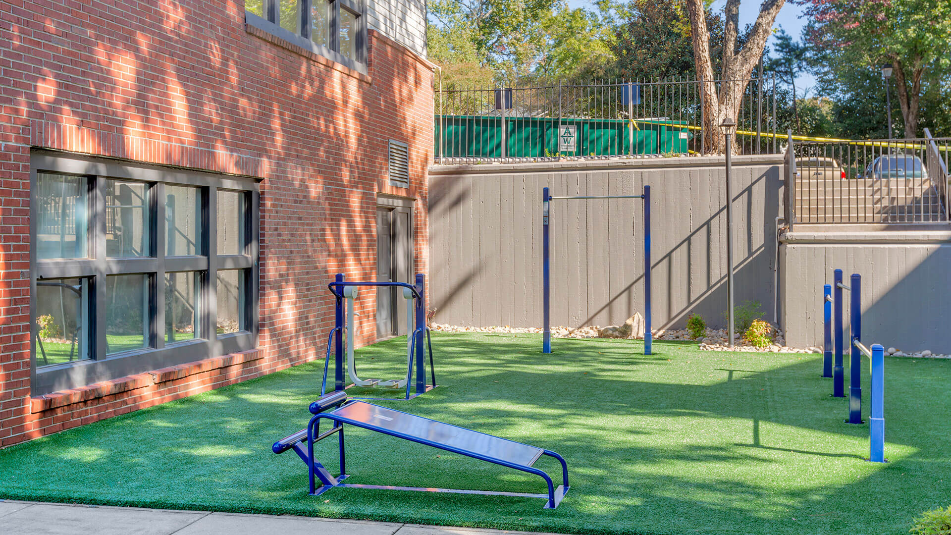 a playground with a blue fence and a blue exercise equipment at The  Jaxon