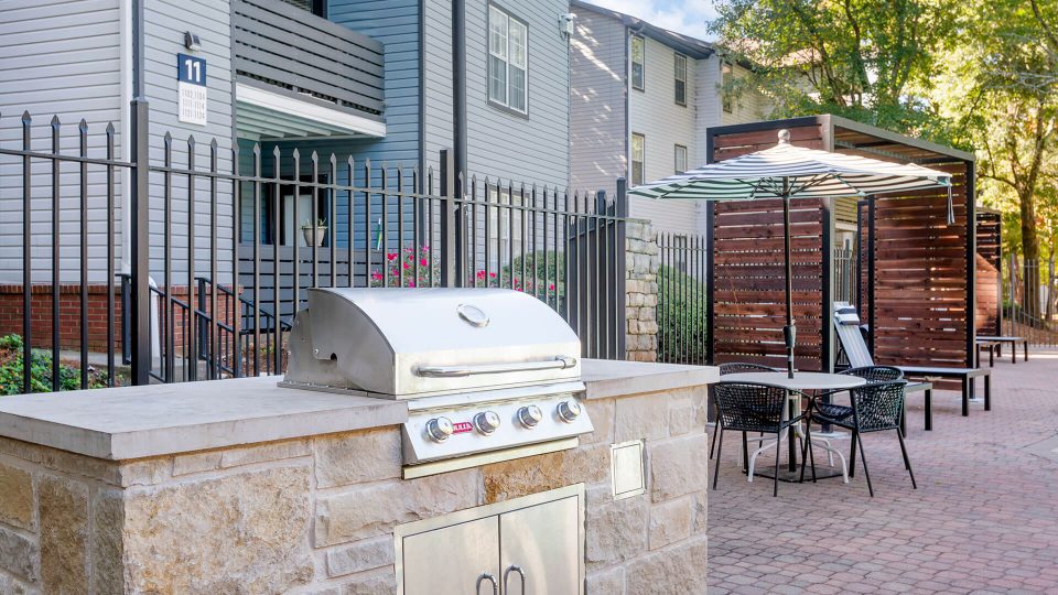 a grill and patio area with a table and chairs at The Jaxon