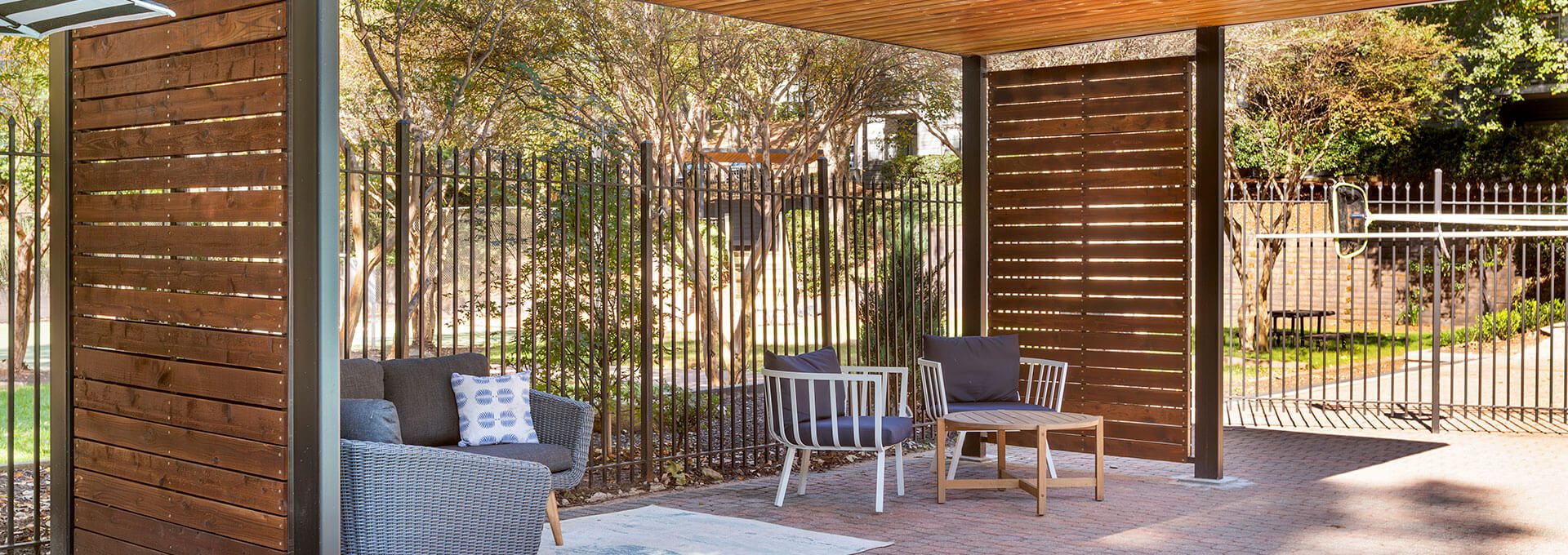a wooden pergol with a bench and chairs at The Jaxon
