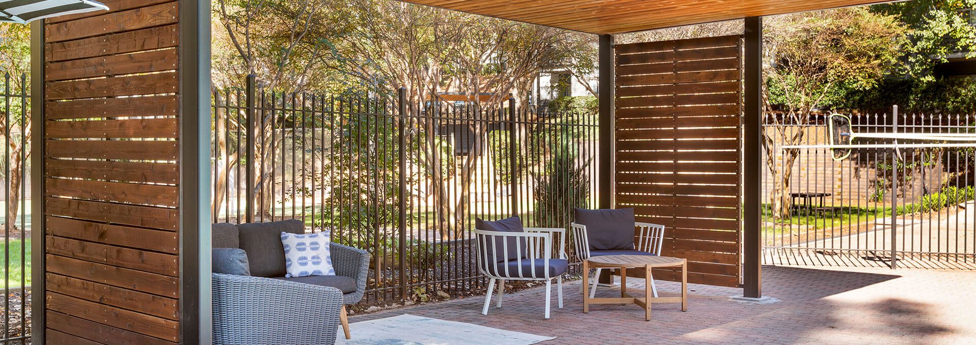 a wooden pergol with a bench and chairs at The  Jaxon